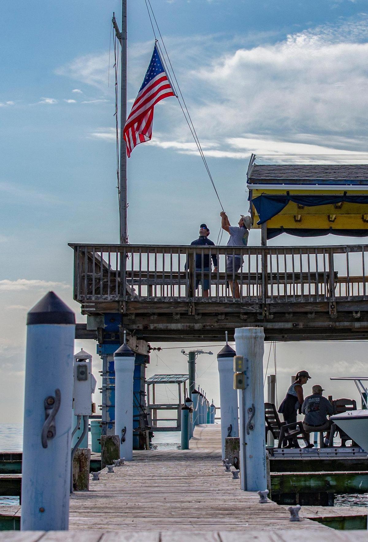 The American flag is raised at the Miami Springs Powerboat Club, on the deck of one of the six remaining wood stilt houses in historic Stiltsville, located one mile south of Cape Florida on Biscayne Bay on Friday, January 15, 2021.