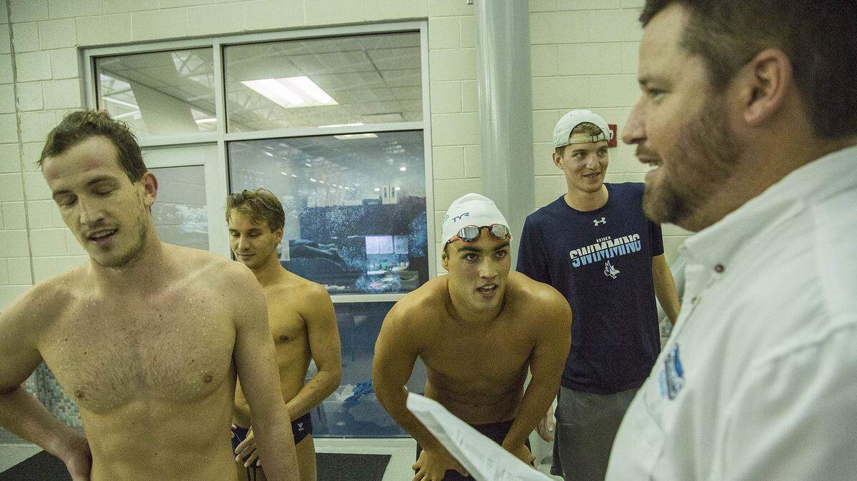 The new St. Thomas University Swimming & Diving Coach Keith Coghlan, at right, is seen at the Sun Coast Conference swimming championships Feb 13, 2020.
