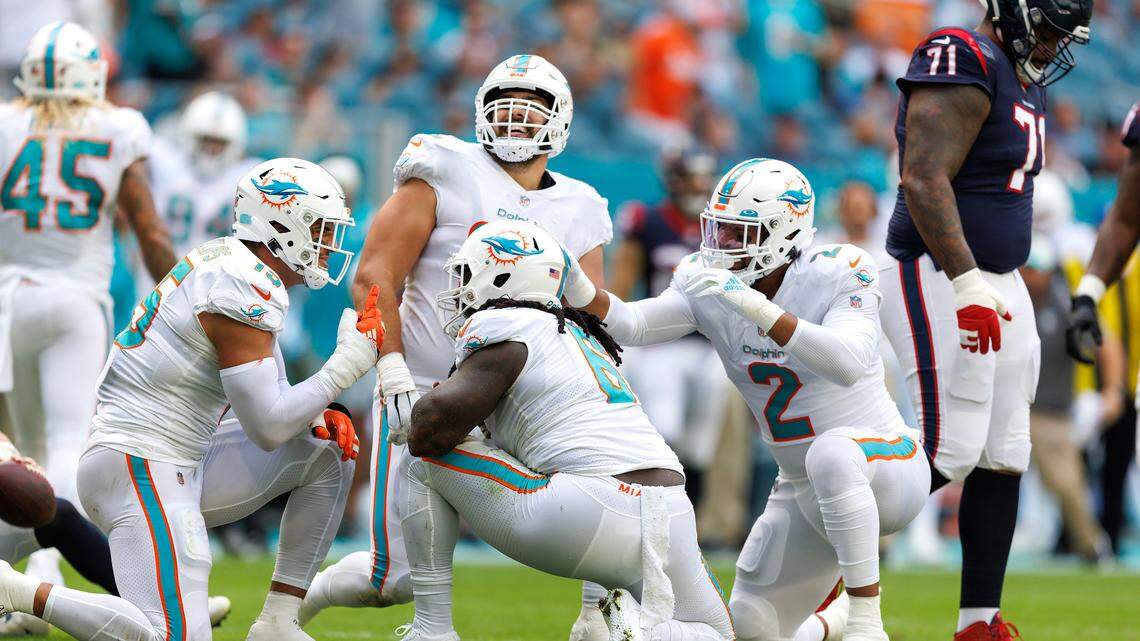 Miami Dolphins players Jaelan Phillips (15) Melvin Ingram (6) Bradley Chubb (2) and Zach Sieler (92) reacting after a defensive play during first quarter of an NFL football game against the Houston Texans at Hard Rock Stadium on Sunday, November 27, 2022 in Miami Gardens, Florida.