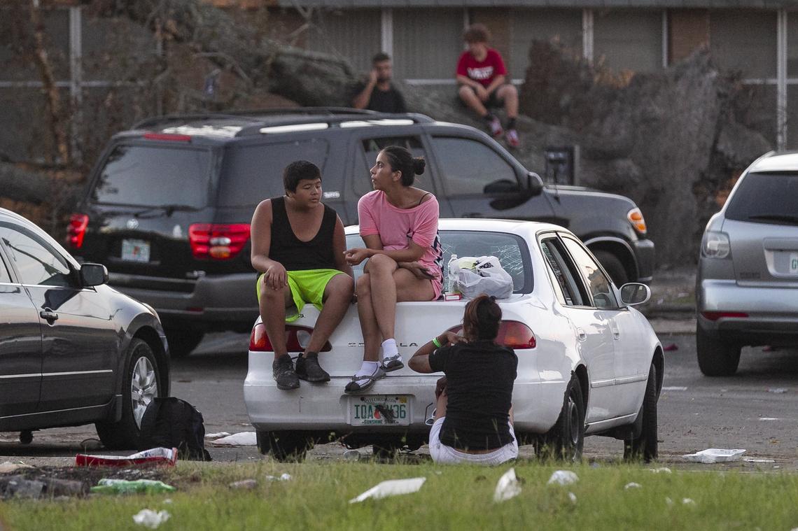 Tony Perez, 13, and his mother, Rosa Perez, 34, sit on top of a car near the remains of their home in a public housing complex that was trashed by Hurricane Michael in Panama City, Florida on Friday, October 19, 2018. The storm has devastated the Florida Panhandle, leaving tens of thousands without food, power or shelter.