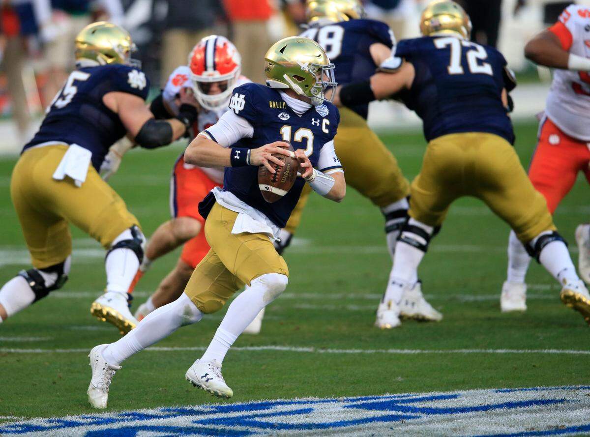 Notre Dame quarterback Ian Book (12) looks for a receiver during the first half of the Atlantic Coast Conference championship NCAA college football game against Notre Dame, Saturday, Dec. 19, 2020, in Charlotte, N.C. (AP Photo/Brian Blanco)
