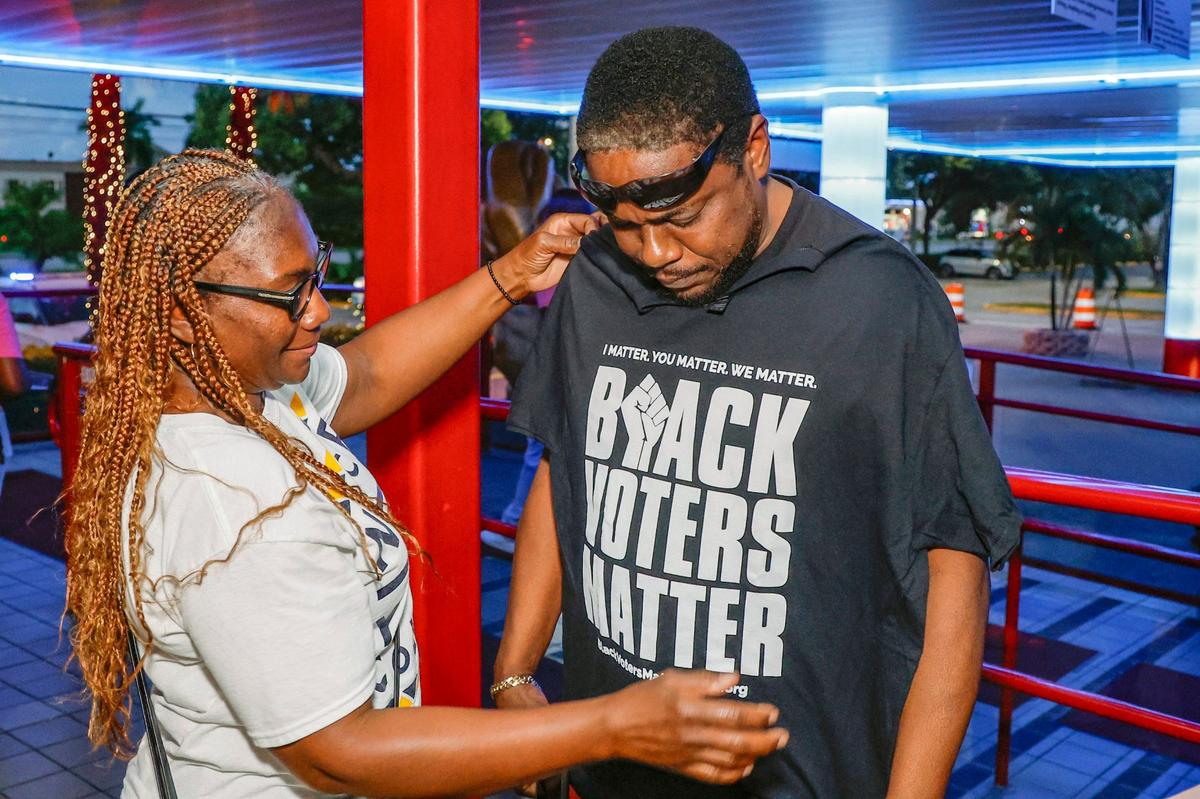 NAACP member Michelle Thompson gives contest winner, K Miller, a Black Voters Matter t-shirt. In an effort to register hard-to-reach voters, NAACP’s Miami-Dade Branch members gathered outside Tootsie’s Cabaret in Miami Gardens on Friday, October 4, 2024, to encourage customers to vote in the November election.