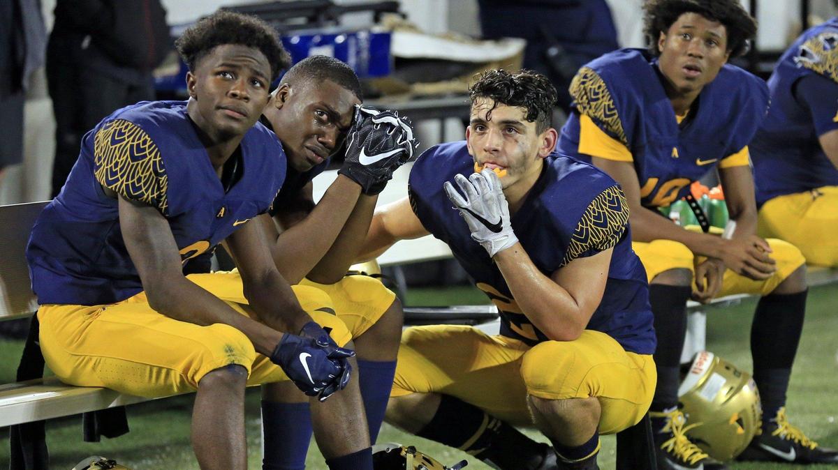 The Raiders Jamal Cooney (3) The’andris Freeman (80) and Xavier Restrepo (21) watch the final moments of the game on the monitor as the Lakeland Dreadnaughts defeat the St. Thomas Aquinas Raiders during the Florida High School Athletic Association State Championship Class 7A at Camping World Stadium in Orlando on Friday, December 7, 2018.
