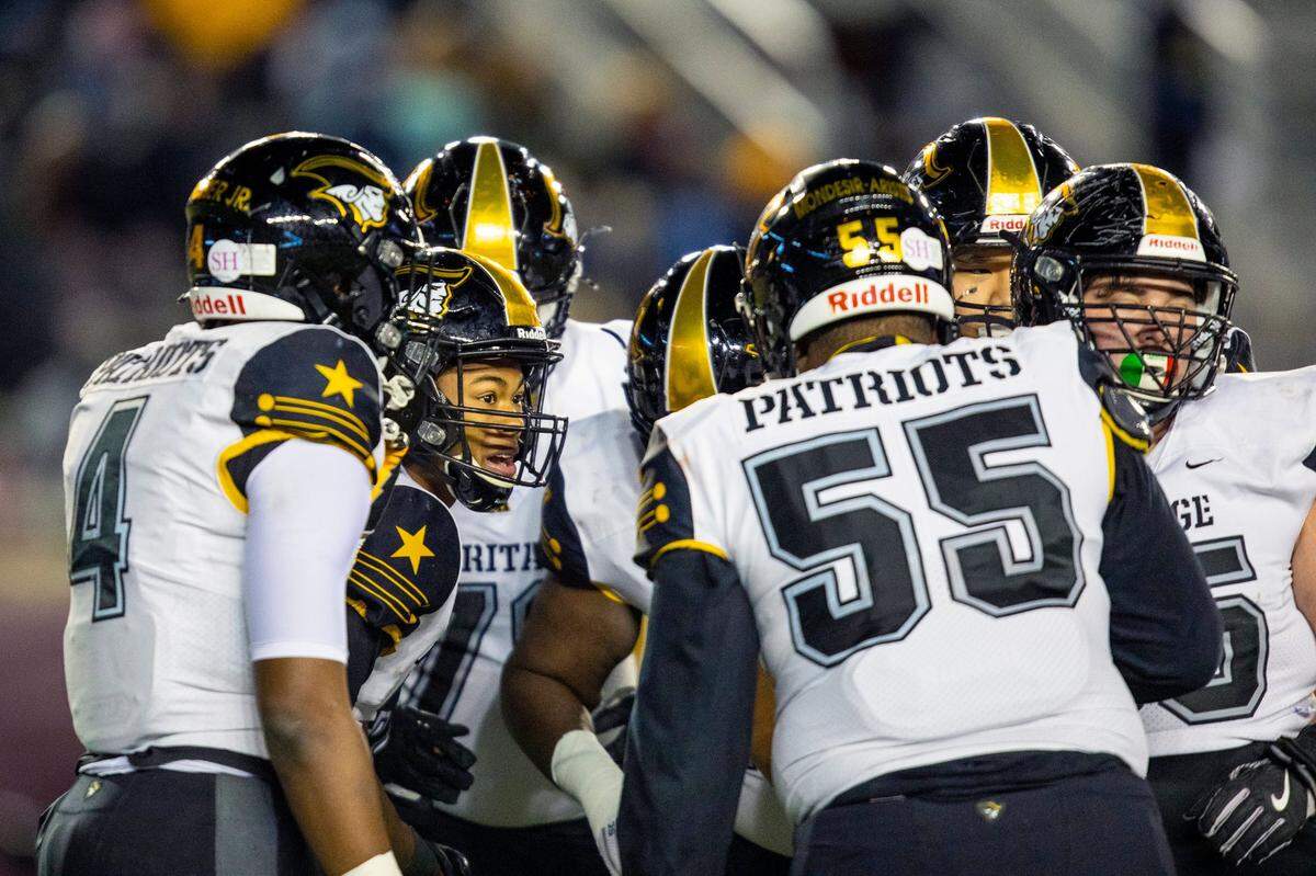 Plantation American Heritage quarterback Blake Murphy (7) speaks to his teammates in the huddle before a play against James S. Rickards High School during the first half of the Class 5A State Championship at Doak Campbell Stadium in Tallahassee, Florida, on Friday, December 18, 2020.