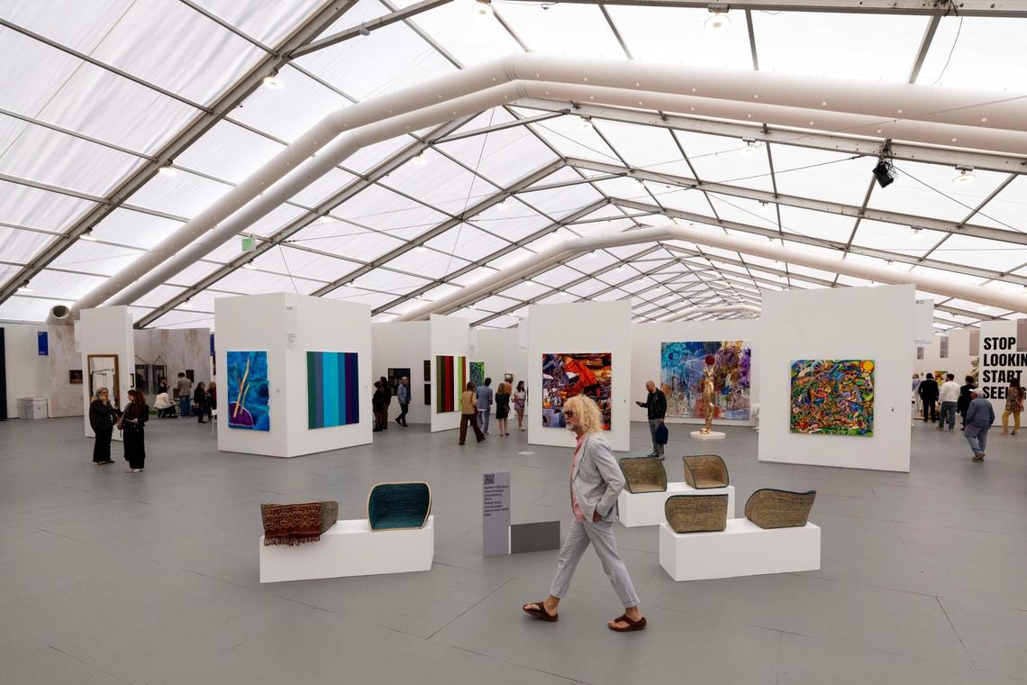 People walk around inside the Untitled Art Fair on Tuesday, Dec. 3, 2024, in Miami Beach, Fla