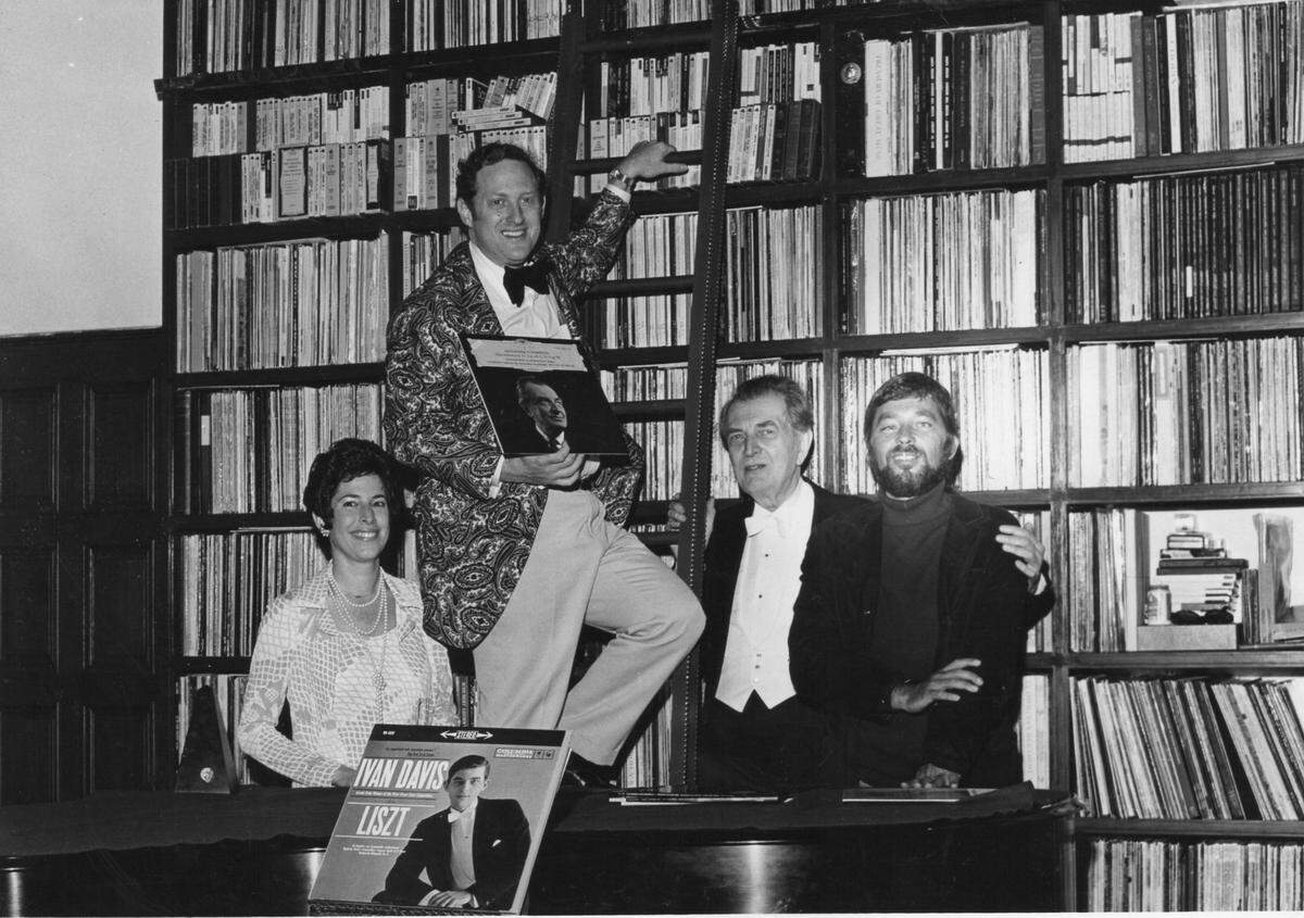 Judith and Julian Kreeger (left) with Ivan Davis (former UM faculty and renowned pianist) and Russian composer/pianist Alexander Thcherepnin at the Kreegers’ home in Miami Beach in an undated photo. Julian Kreeger pulls recordings for each of them out of his record collection. The ladder was necessary as thousands of the recordings were on shelves 8-20 feet above the ground level of the living room, his family said.