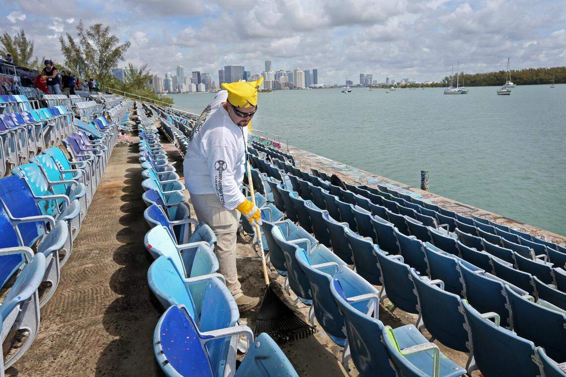 Tourism industry volunteers work on restoration efforts at the Miami Marine Stadium in 2014. Carlos Suarez, with Royal Caribbean Cruises, uses a rake to clear garbage and debris from underneath the seats at the stadium.