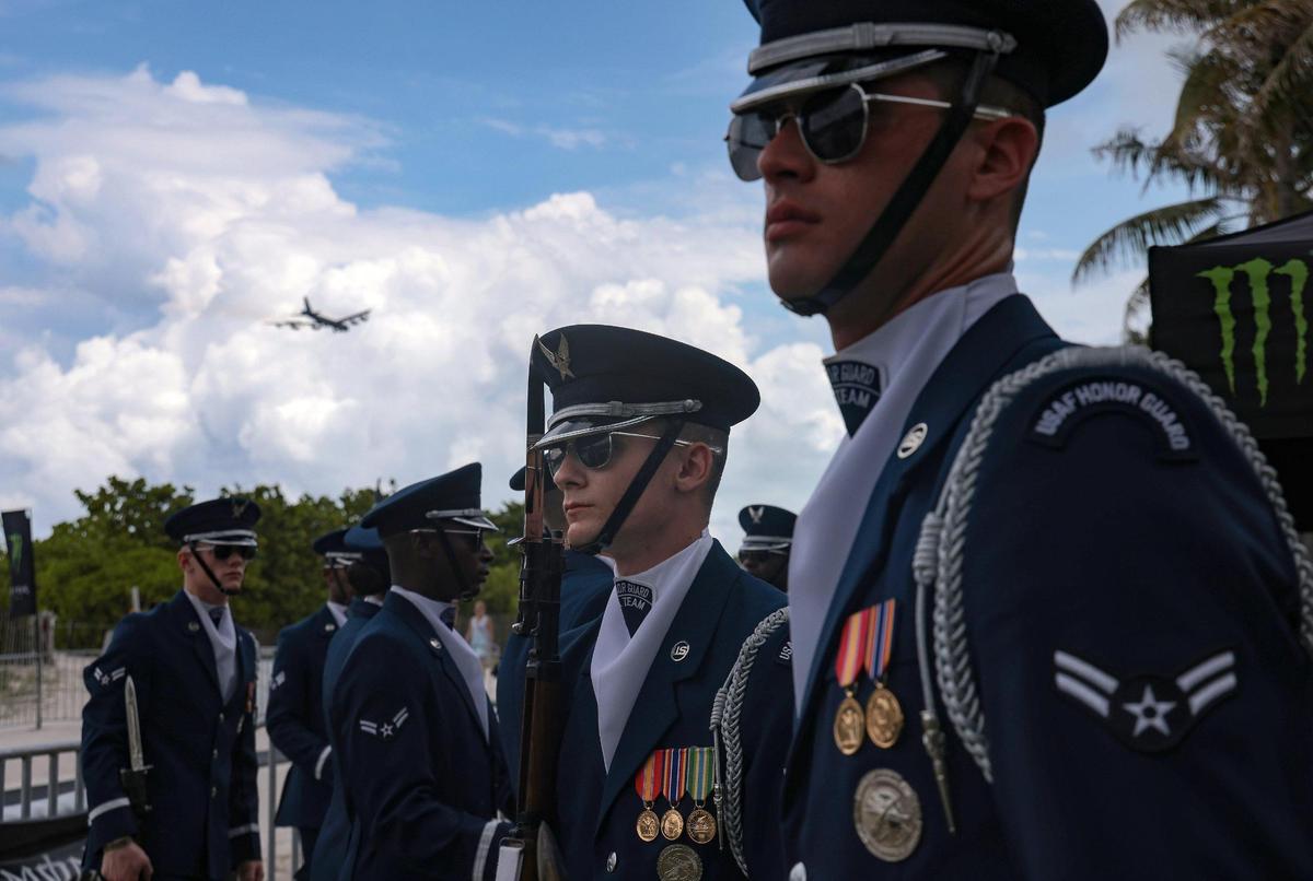 Air Force honor guards wait to participate in freestyle professional motorcross performance. On Sunday, May 29, 2022 motorcycle acrobatics met military precision in South Beach Sunday, as an Air Force honor guard performed drills on the sand as professional motorcross drivers jump their bikes in Lummus Park in South Beach.