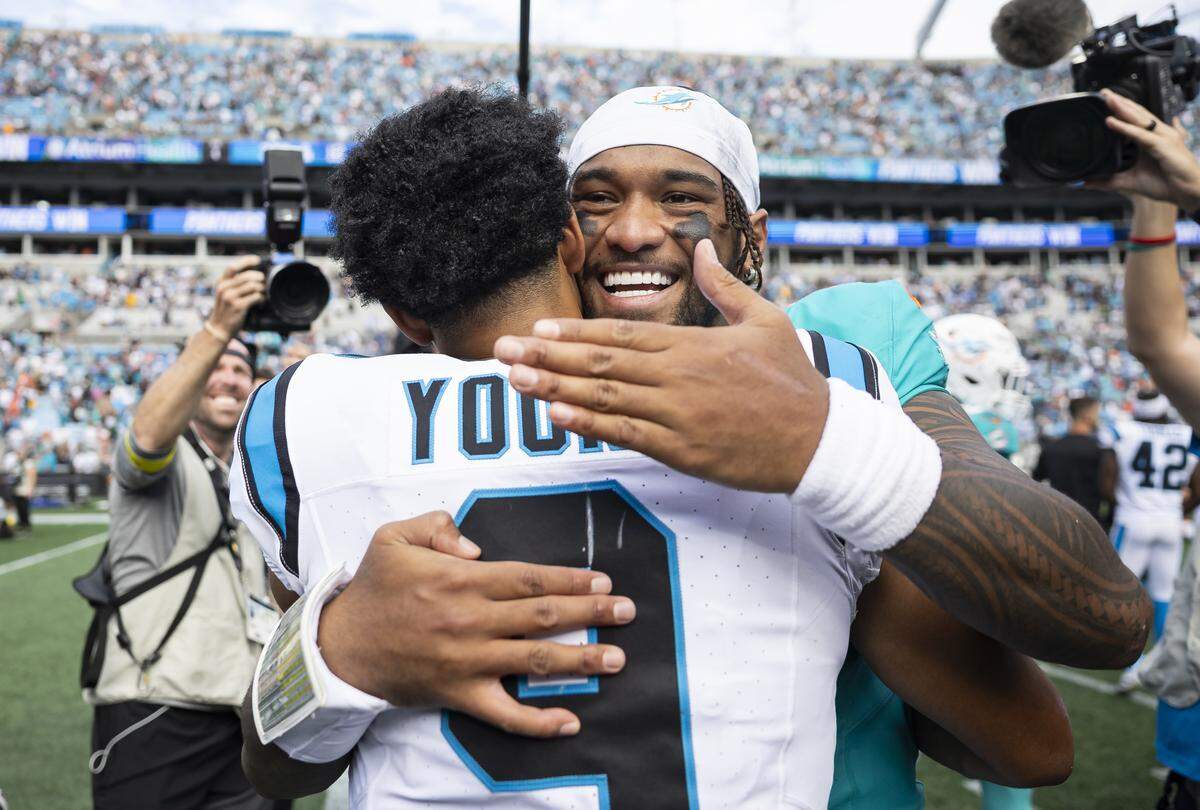 Miami Dolphins quarterback Tua Tagovailoa (1) hugs Carolina Panthers quarterback Bryce Young (9) after their NFL game at the Bank of America Stadium on Sunday, Oct. 5, 2025, in Charlotte, N.C.