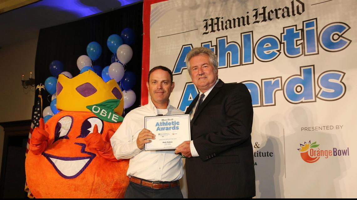 Cardinal Gibbons football coach Matt Dubuc is presented the 2018-2019 Coach of the Year award for 5A-IND football division by Miami Herald high school sports reporter Bill Daley during the Miami Herald Athletic Awards All-Broward banquet, Tuesday, May 21, 2019 at the Signature Grand in Davie. Dubuc also went on to win Male Sports Coach of the Year during the event.