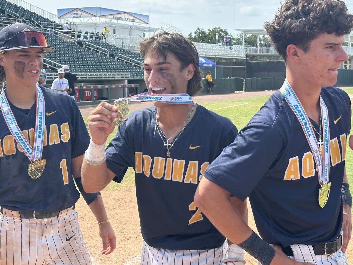 St. Thomas Aquinas shortstop Jaden Doverspike (middle) shows off his state championship medal after the Raiders won the Class 6A state title for the second year in a row.