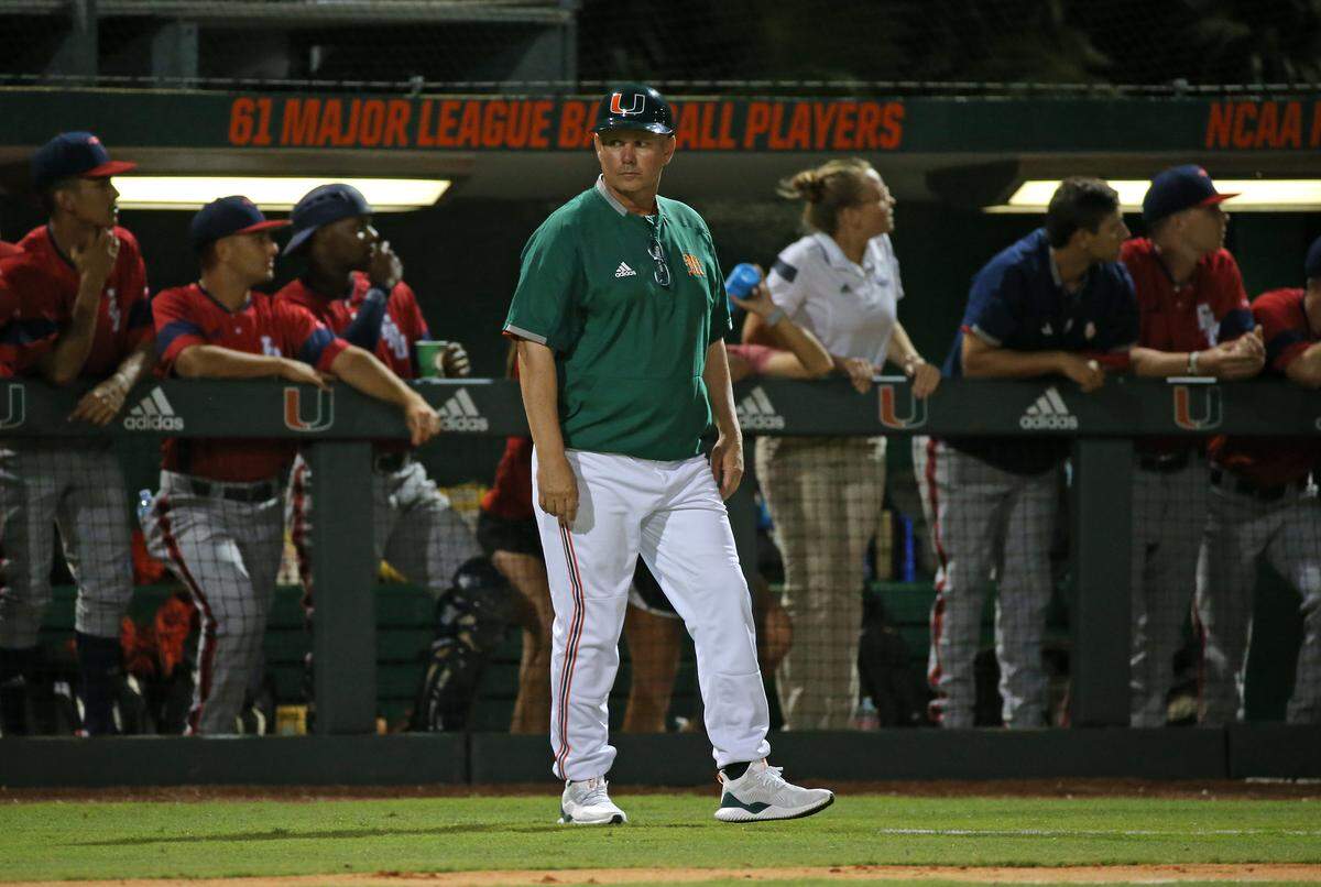 Miami Hurricanes head coach Gino DiMare (6) looks on at third base during the third inning of a NCAA baseball game against the Florida Atlantic University Owls at Alex Rodriguez Park at Mark Light Field on Wednesday, February 20, 2019 in Coral Gables.