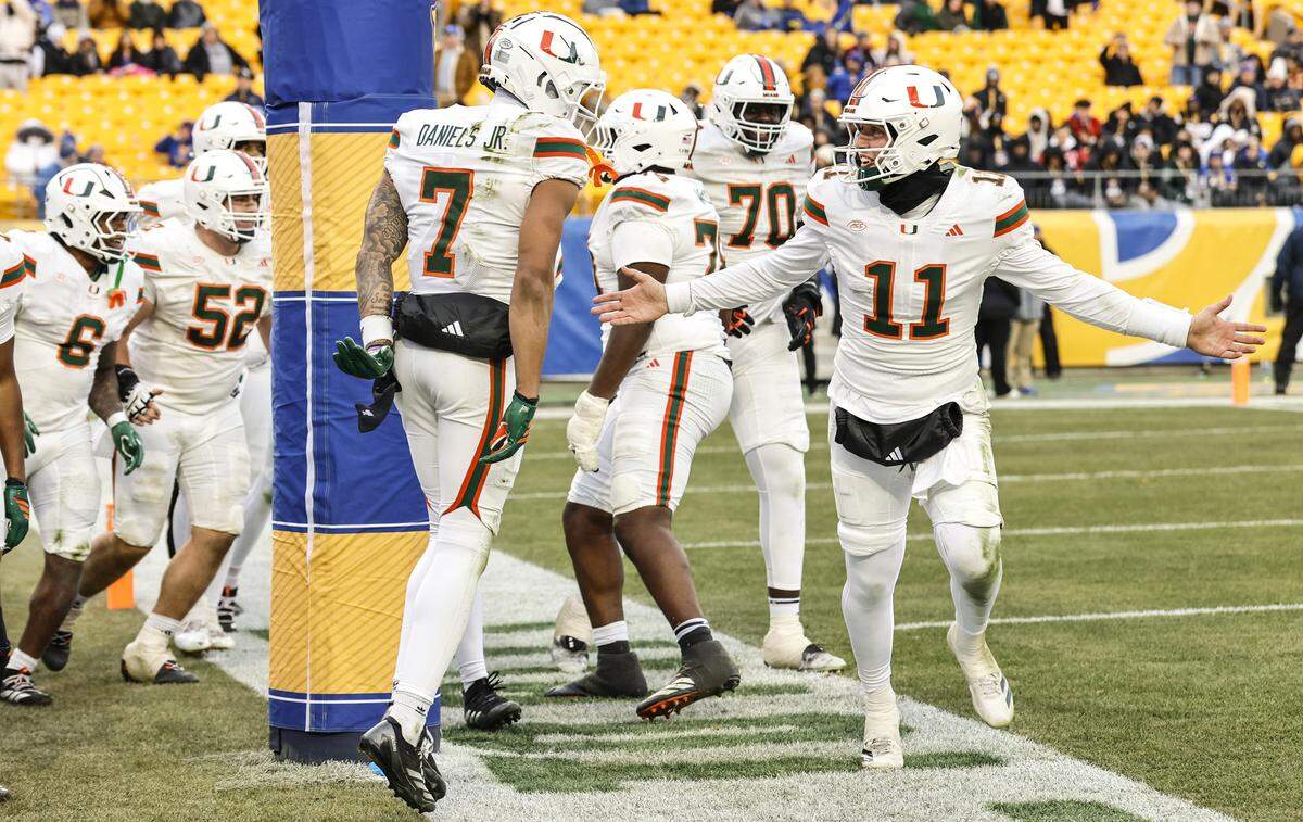 Miami Hurricanes wide receiver CJ Daniels (7) and quarterback Carson Beck (11) celebrate after Daniels scores on a pass reception from Beck during the second half of their NCAA football game against the Pittsburgh Panthers at Acrisure Stadium in Pittsburgh, PA, on Saturday, November 29, 2025.