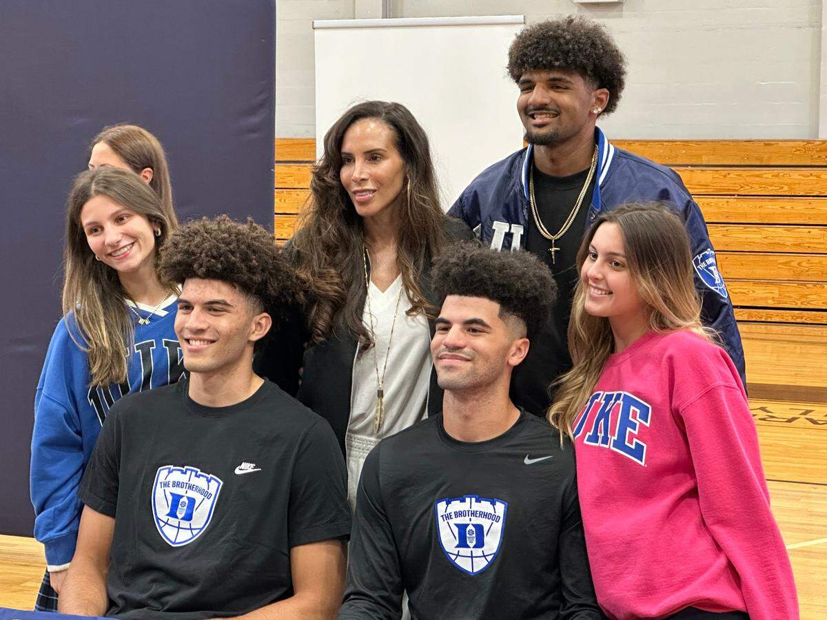 Columbus basketball stars Cameron and Cayden Boozer pose for photos with their family during their signing ceremony on Thursday at Columbus High School. The Boozers both signed with Duke University.
