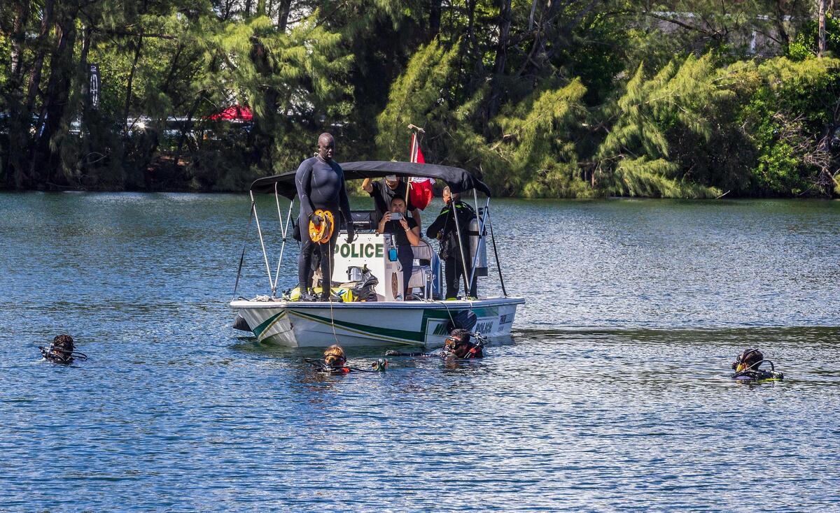 Buzos de la Policía y del Cuerpo de Bomberos de Miami-Dade se preparan para sacar un auto de un lago en Doral, el martes 8 de agosto de 2023. Los buzos localizaron el martes 8 de agosto de 2023 unos 20 vehículos en el lago, tras el aviso de un equipo de buzos voluntarios que descubrió más de 30 autos en el lago cerca de Northwest 13th Terrace.