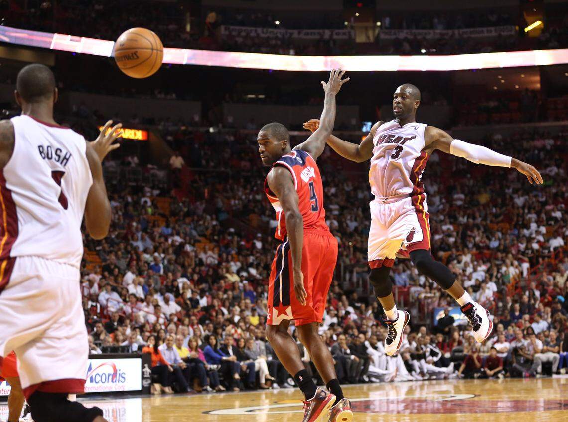 Dwyane Wade passes to Chris Bosh past Bradley Beal during the 3rd quarter of the NBA basketball game between the Miami Heat and the Washington Wizards at AmericanAirlines Arena in Miami on Nov. 3, 2013.