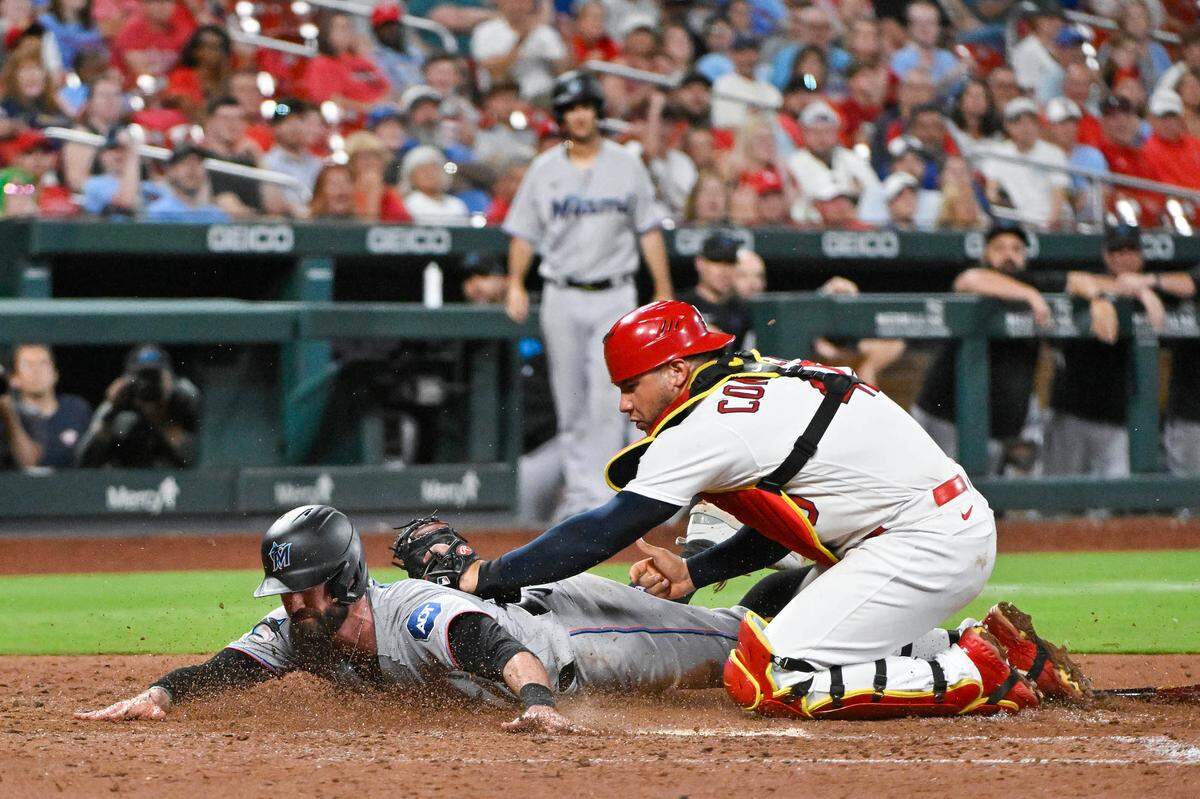 St. Louis Cardinals catcher Willson Contreras (40) tags out Miami Marlins shortstop Jon Berti (5) at the plate during the ninth inning at Busch Stadium.