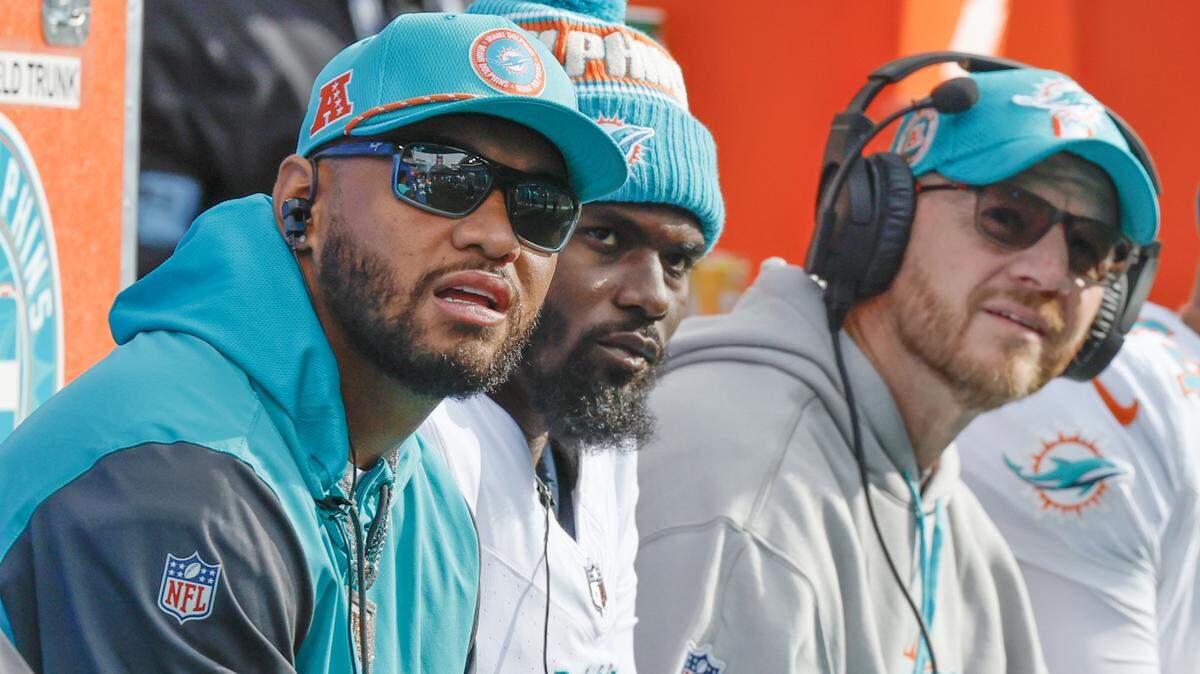 Los quarterbacks de los Dolphins Tua Tagovailoa (izq.) y Tyler Huntley (c) junto a su coordinador Darrell Bevell observan el juego desde el banco en el Lumen Field en Seattle, Washington, el domingo 22 de septiembre de 2024.