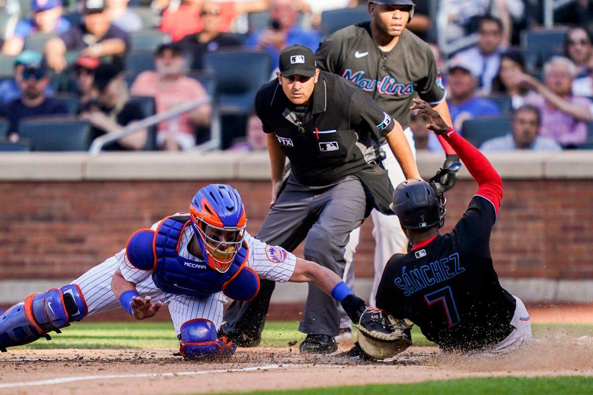 New York Mets catcher James McCann (33) tags out Miami Marlins’ Jesus Sanchez (7) at home in the sixth inning of a baseball game, Saturday, July 9, 2022, in New York. (AP Photo/John Minchillo)