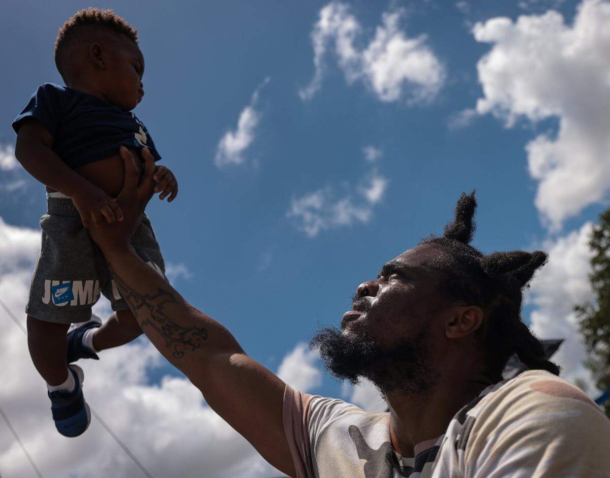 Miami Garden resident Barcardius, 1, is lifted up in the air by his father Bryan Friedman while passing the time waiting in the long line to attending the Easter Day Eggstravaganza. Thousands stood in line to claim their wristbands for the event, which featured a helicopter egg drop, live performances, food trucks, a Kid Zone, rides, games, and other family oriented entertainment.