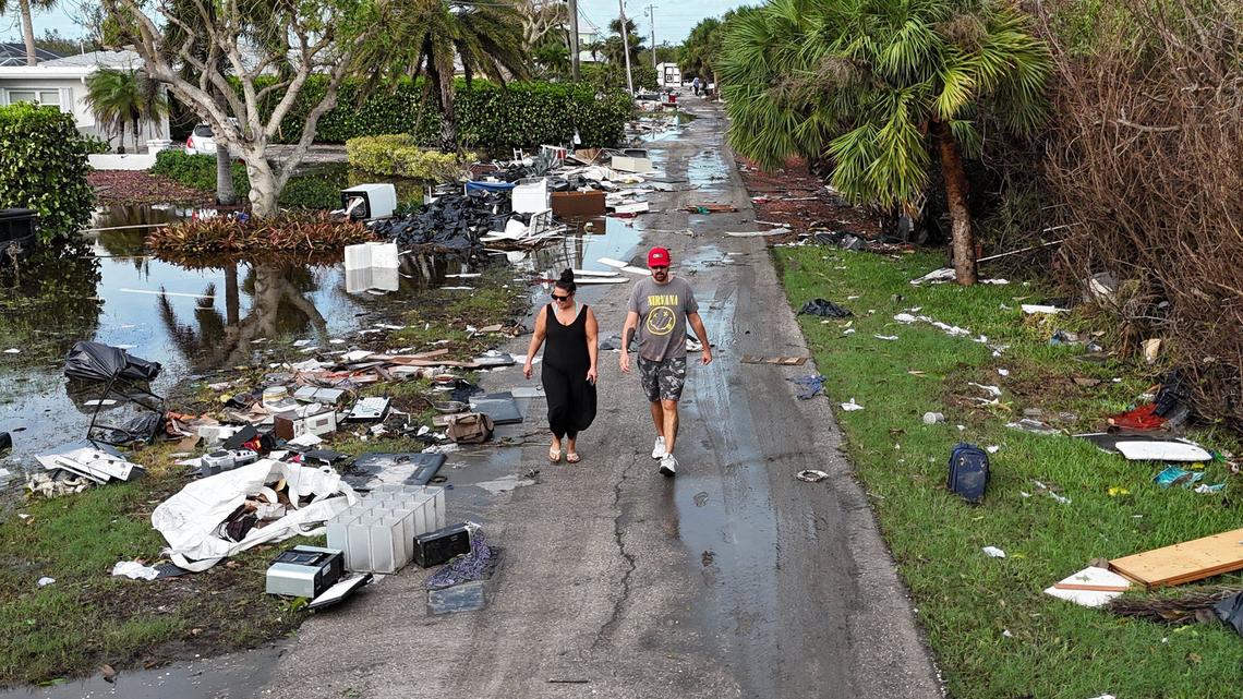 Brian Rhodes and Trish Cloutier surveying damage and debris in front of homes in Charlotte County near Manasota Key on Thursday, Oct. 10, 2024, the morning after Hurricane Milton hit the area.