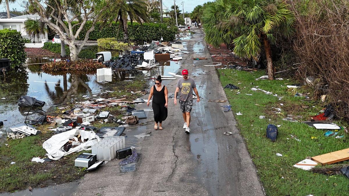 Los lugareños Brian Rhodes y Trish Cloutier inspeccionan los daños y los escombros frente a las casas en el Condado Charlotte, cerca de Manasota Key, el jueves 10 de octubre de 2024, la mañana después de que el huracán Milton azotara el área.