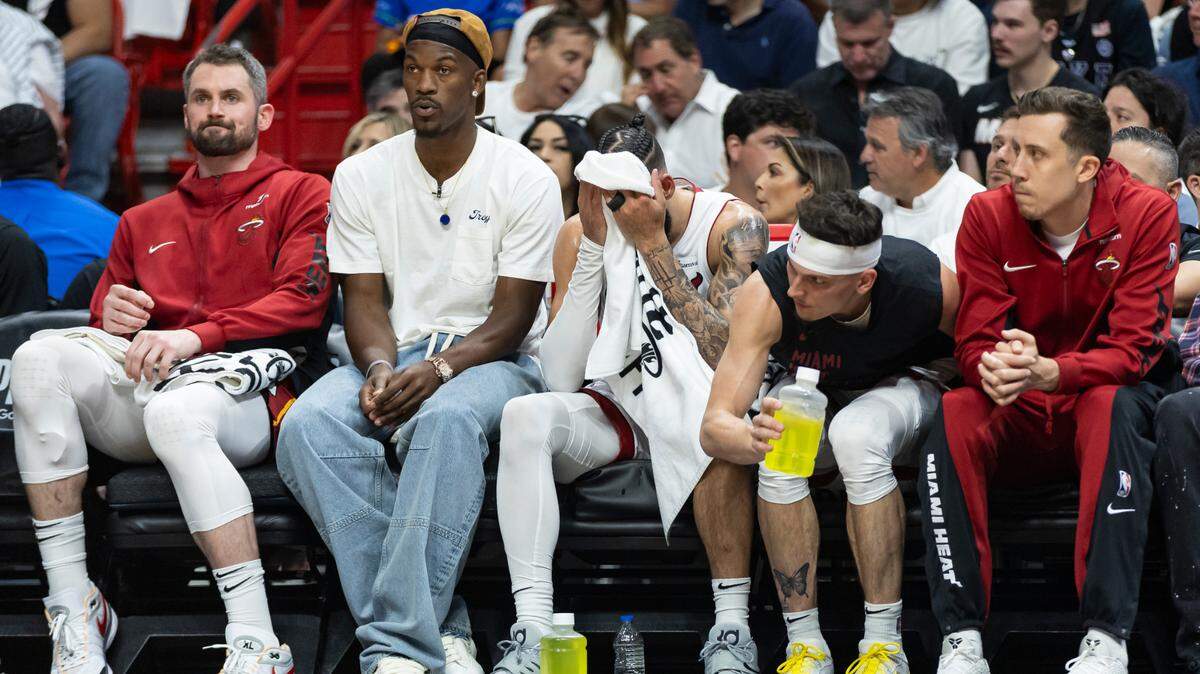 Miami Heat’s Kevin Love (42), Jimmy Butler (22), Caleb Martin (16), Tyler Herro (14) and Duncan Robinson (55) look on from the bench as their team plays against the Boston Celtics in the first half of Game 4 of their first-round playoff series at Kaseya Center on April 29, 2024, in Miami.