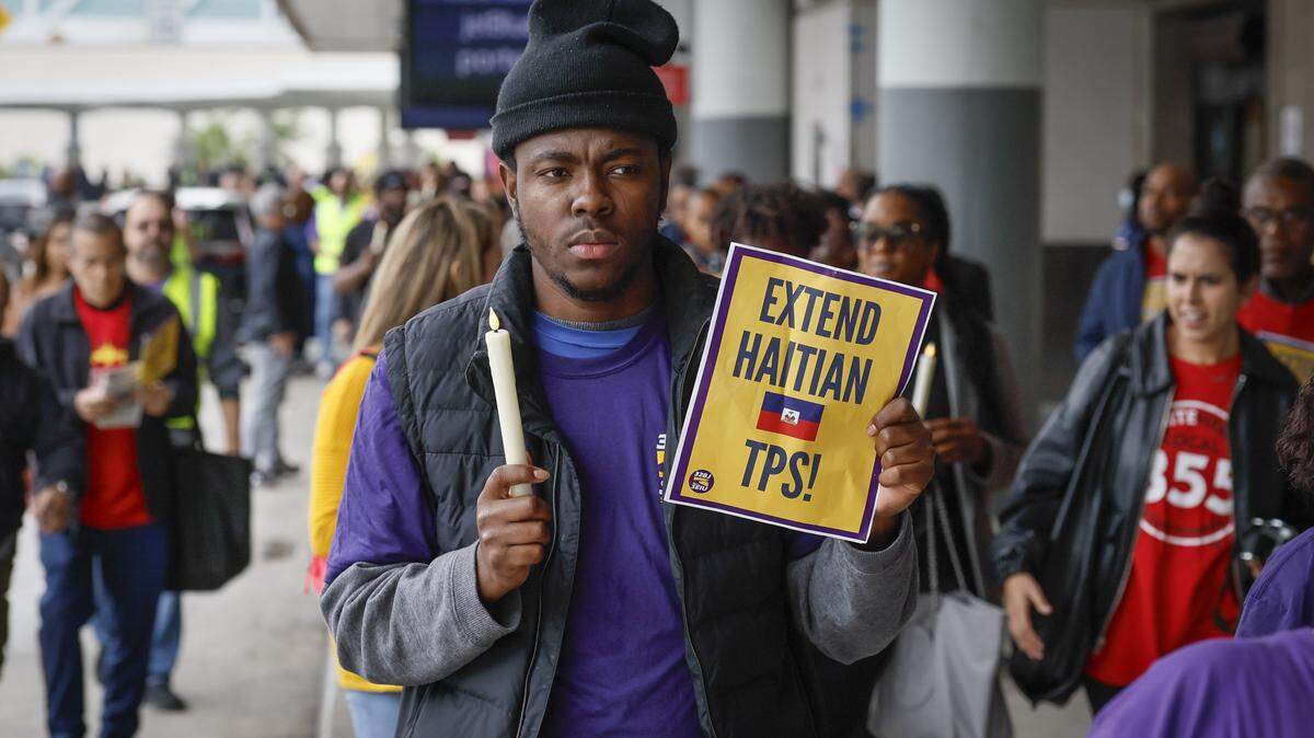 Yronel Cabrera walks with protesters during a candlelight vigil and interfaith prayer at Fort Lauderdale–Hollywood International Airport on Jan. 28 calling on the Trump administration to extend Temporary Protected Status for Haiti.