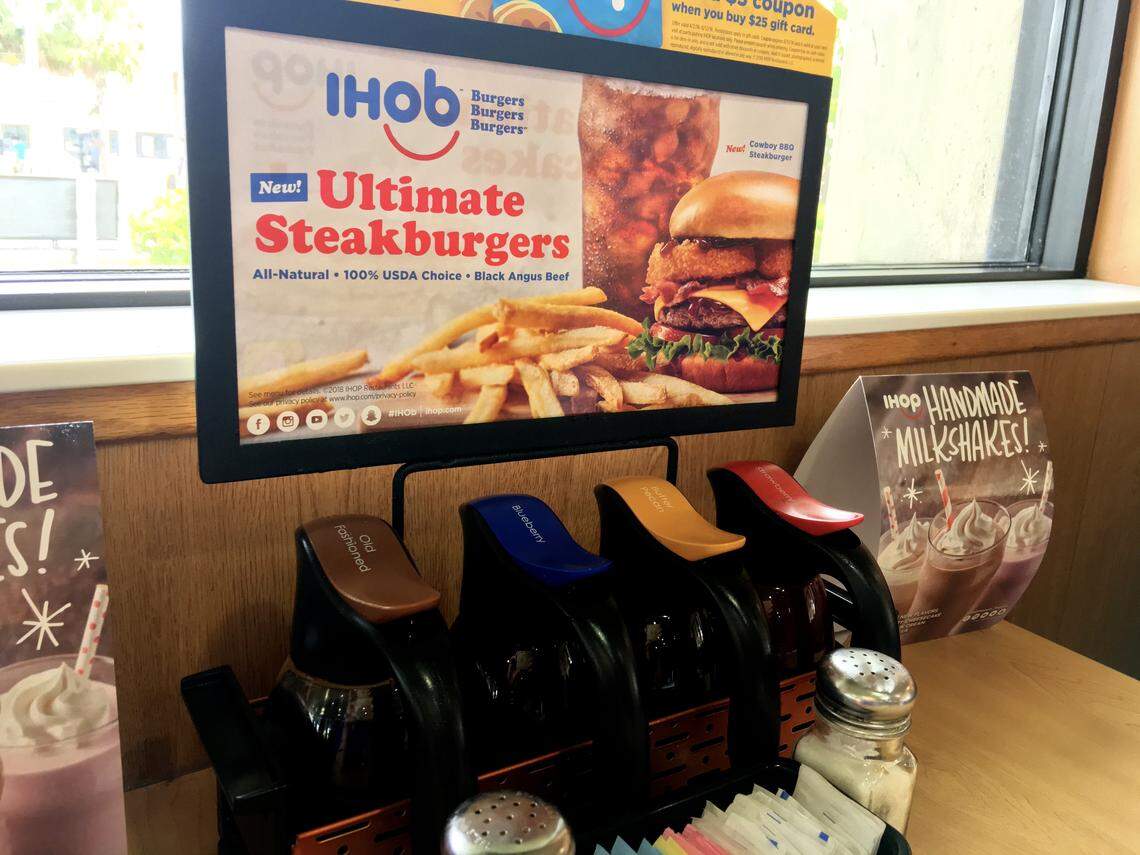 International House of Pancakes touts its burgers above its tabletop pancake syrup offerings at a Sunset Drive IHOP on June 12, 2018.