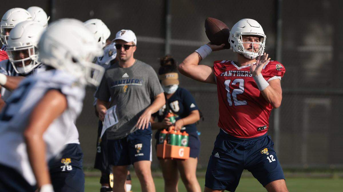 Quarterback Gunnar Holmberg, right, takes the snap and looks cross field during passing drills at practice. On Monday, August 1, 2022 FIU football team opened morning practiced to the media on the practice field on the Tamiami Campus.