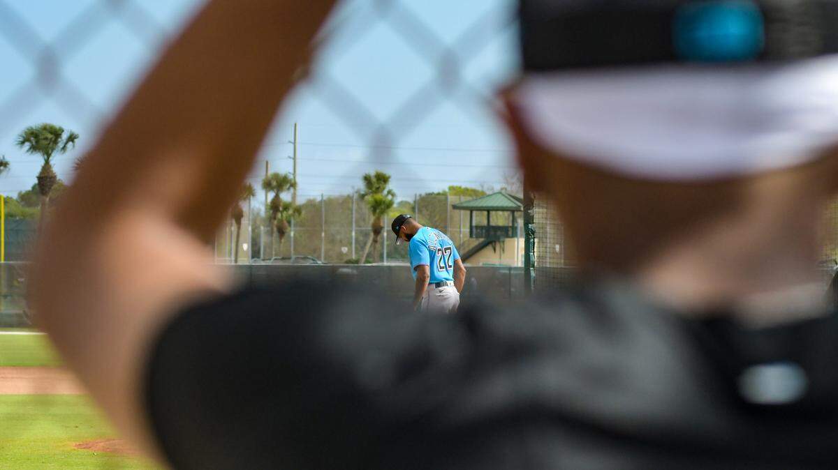 Miami Marlins pitcher Eury Perez (foreground) watches from along a fence as pitcher Sandy Alcantara throws a live batting practice session on Sunday, Feb. 19, 2023, at the Roger Dean Chevrolet Stadium complex in Jupiter, Florida.