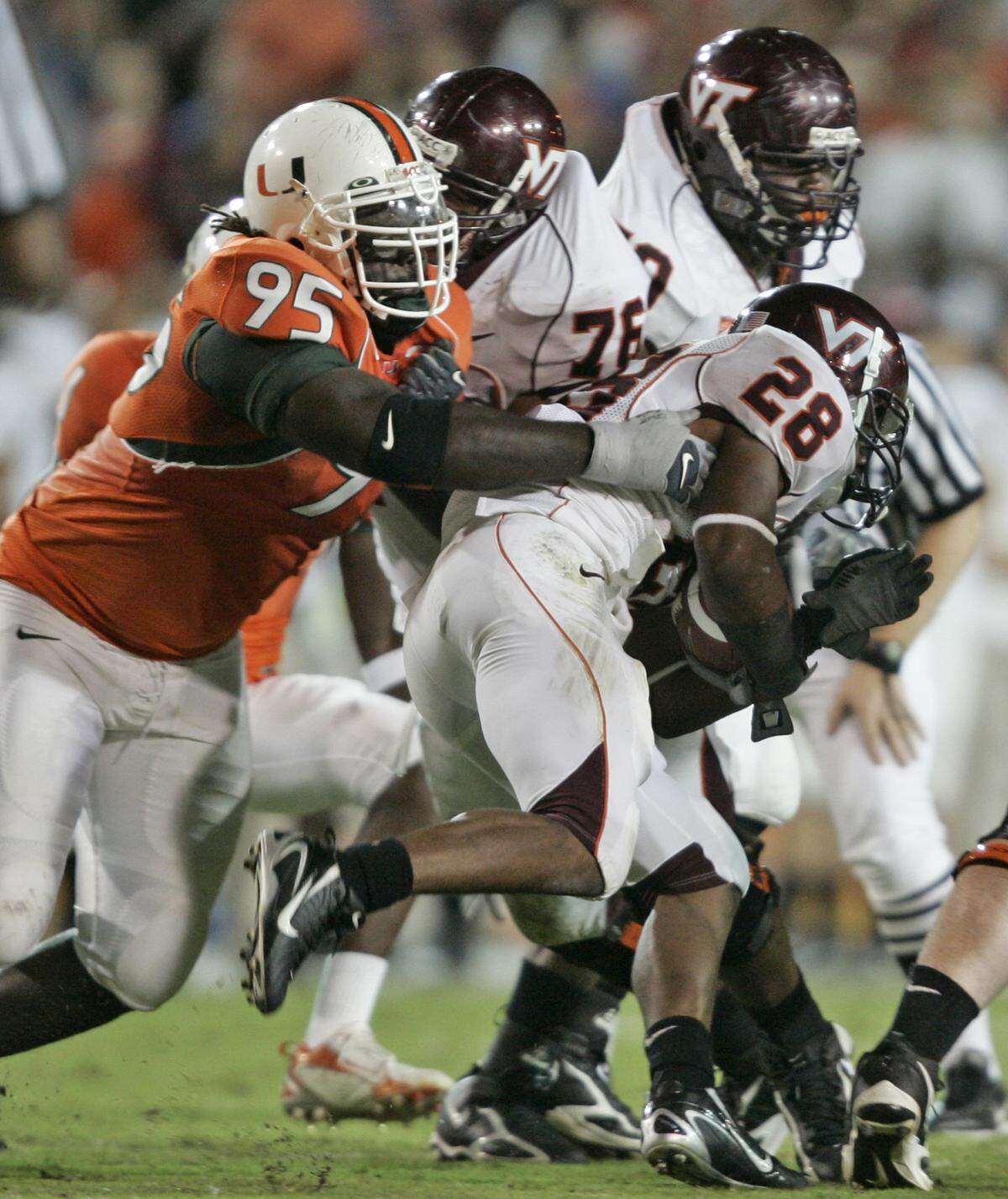 11/3/06 Al Diaz/Miami Herald Staff--Miami--Virginia Tech vs The University of Miami at the Orange Bowl. UM’s Bryan Pata takes down VT’s Branden Ore.