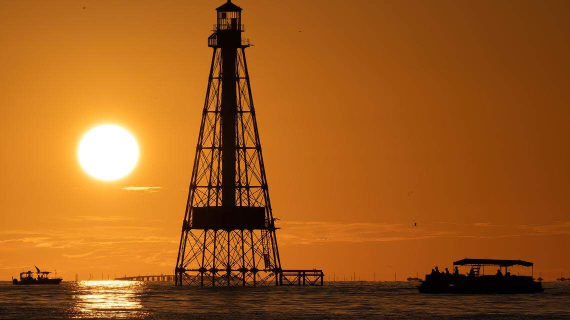 Boaters watch a sunset behind Alligator Reef Lighthouse Friday, Oct. 6, 2023, off Islamorada in the Florida Keys.