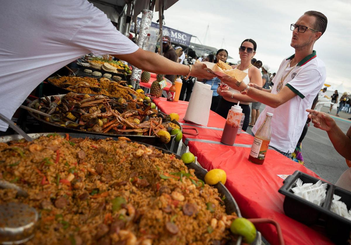 People order plates of jambalaya and Caribbean seafood broil during Jazz in the Gardens on Sunday, March 10, 2024, at Hard Rock Stadium in Miami Gardens.
