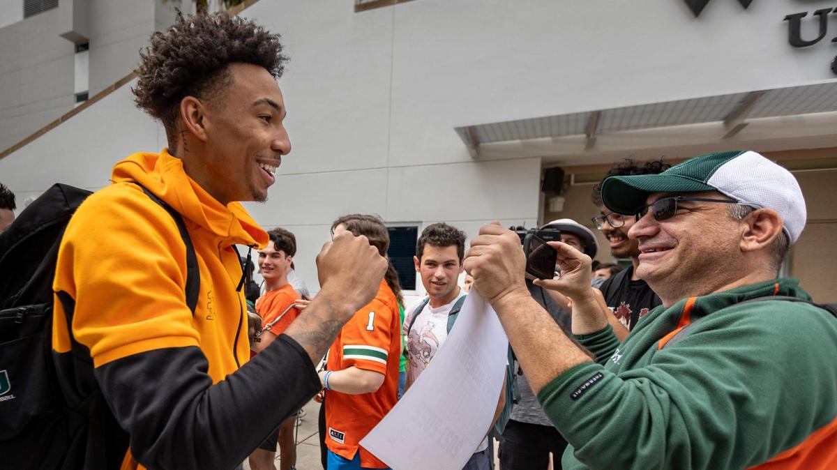 Miami, FL- March 19, 2023 - University of Miami Guard, Jordan Miller, left, greets fans after getting off the bus at the Watsco Center at the University of Miami. The team arrived home this afternoon after qualifying for the Sweet 16 in the NCAA Tournament.
