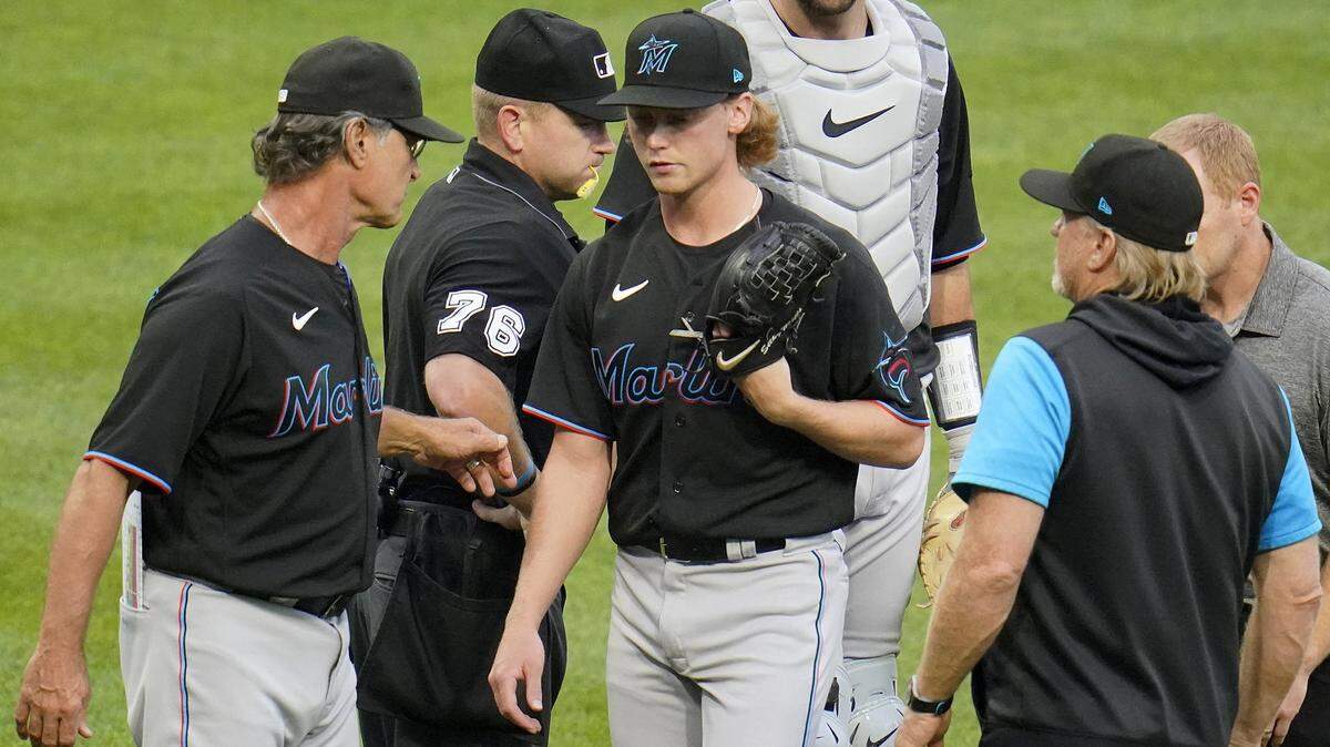 Miami Marlins starting pitcher Max Meyer, center, walks off the mound past manager Don Mattingly, left, with an unknown injury, during the first inning of a baseball game against the Pittsburgh Pirates in Pittsburgh, Saturday, July 23, 2022.
