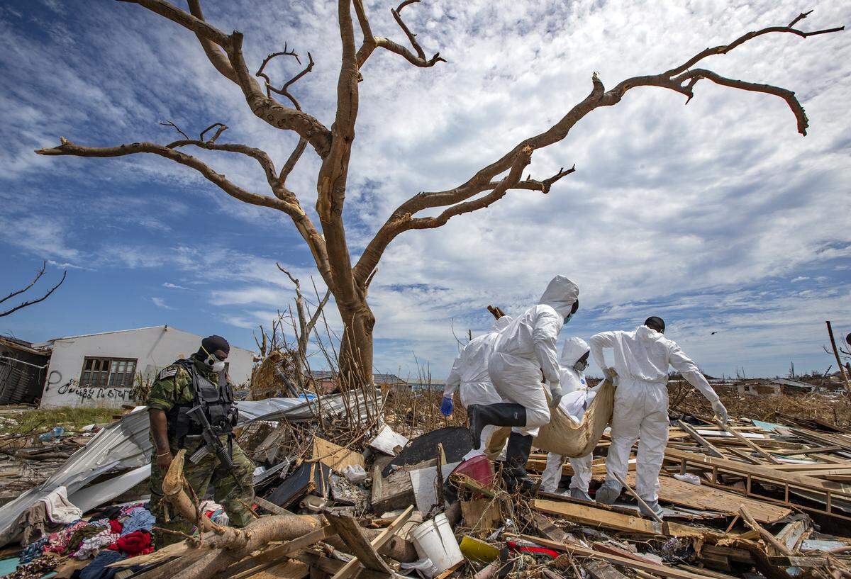 The body of a victim killed by Hurricane Dorian is carried out of The Mudd by Royal Bahamas Police Crime Scene Investigators in Marsh Harbour on Abaco Island on Sunday, September 8, 2019.