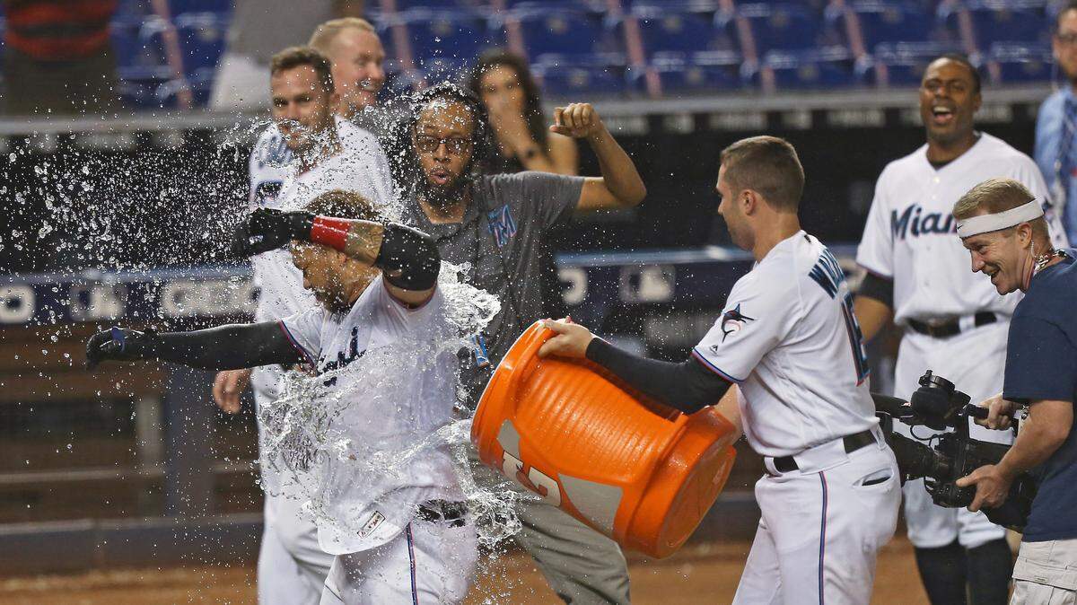 Miami Marlins right fielder Harold Ramirez (47) got dump with a cooler of water by teammate Neil Walker after hitting a solo walk-off home run during the twelfth inning of a Major League Baseball game against the Cincinnati Reds at Marlins Park in Miami on Thursday, August 29, 2019. Marlins won 4-3.