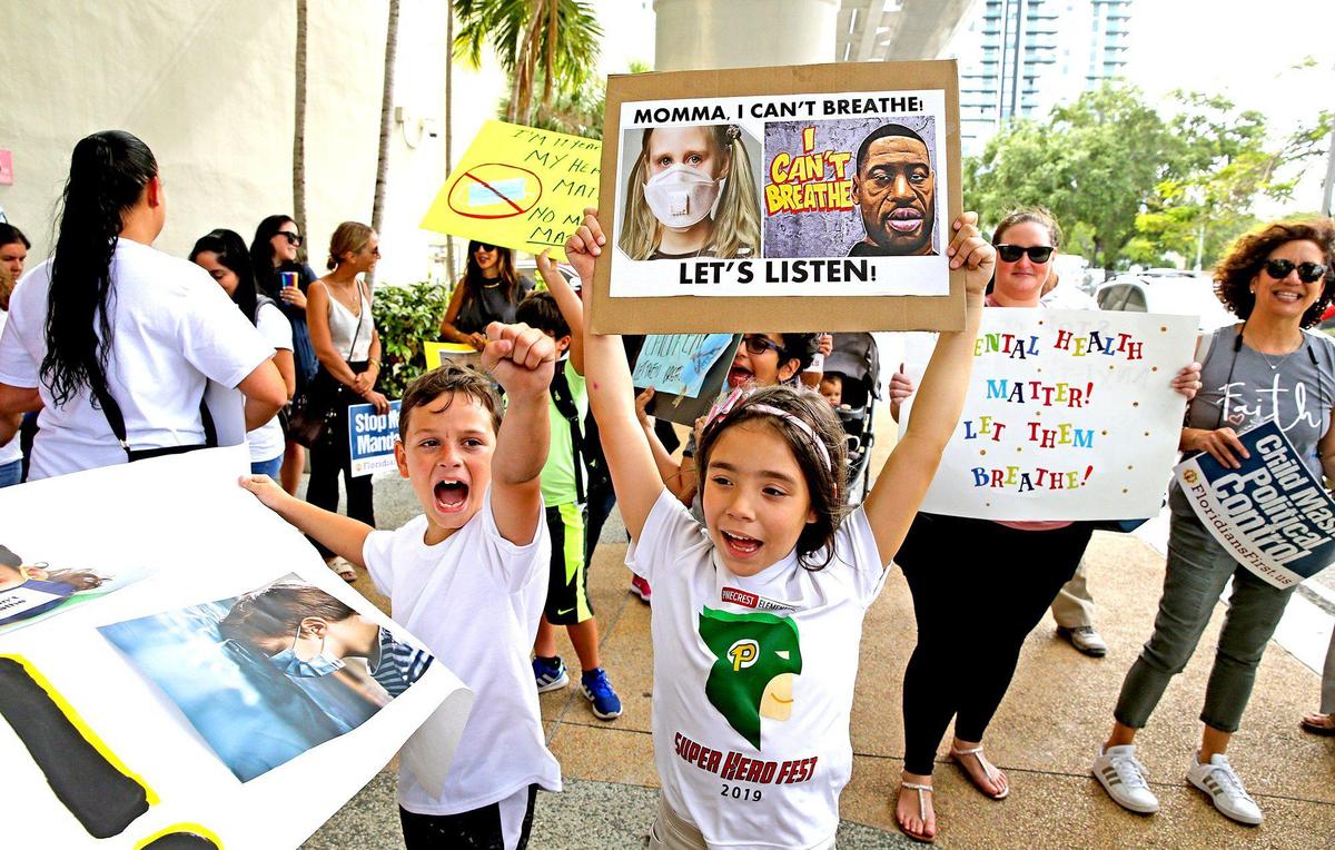 Ryan Pazze, 8, and Melanie Montes, 7, at an “Un-mask Our Kids” rally at the School Board administration building on May 19, 2021. Twenty-one speakers signed up to speak about masks during public comment. Many are against masks in schools.