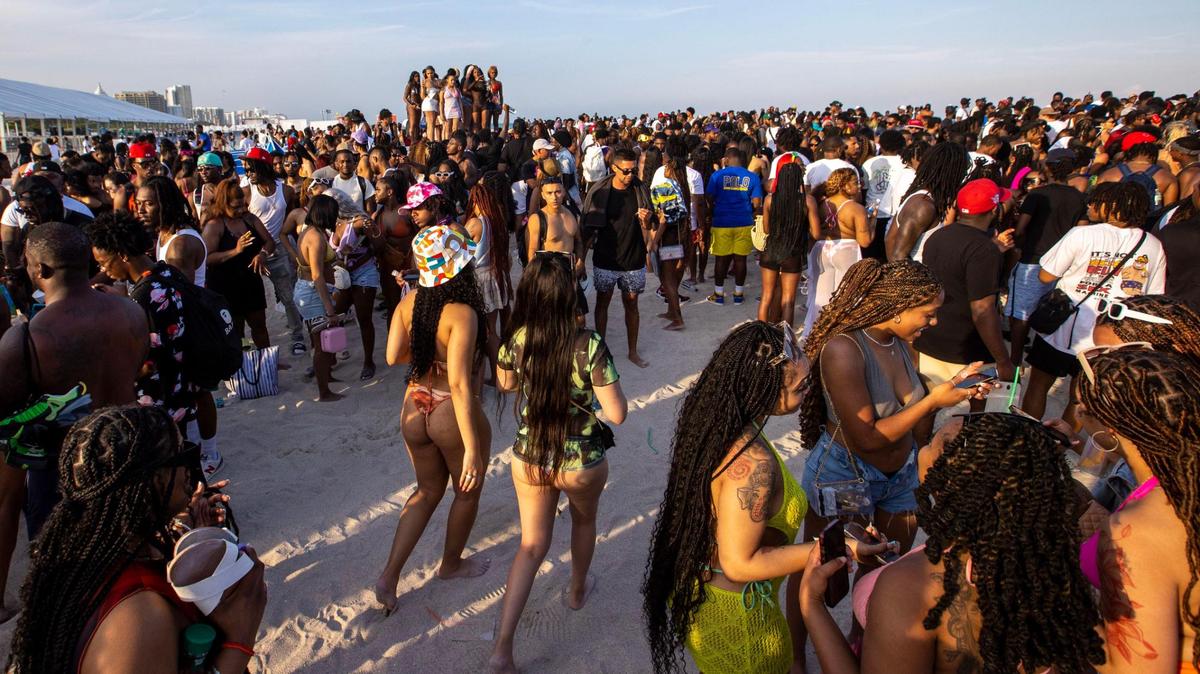 Spring breakers socialize on the beach during Spring Break in Miami Beach, Florida, on Saturday, March 18, 2023.