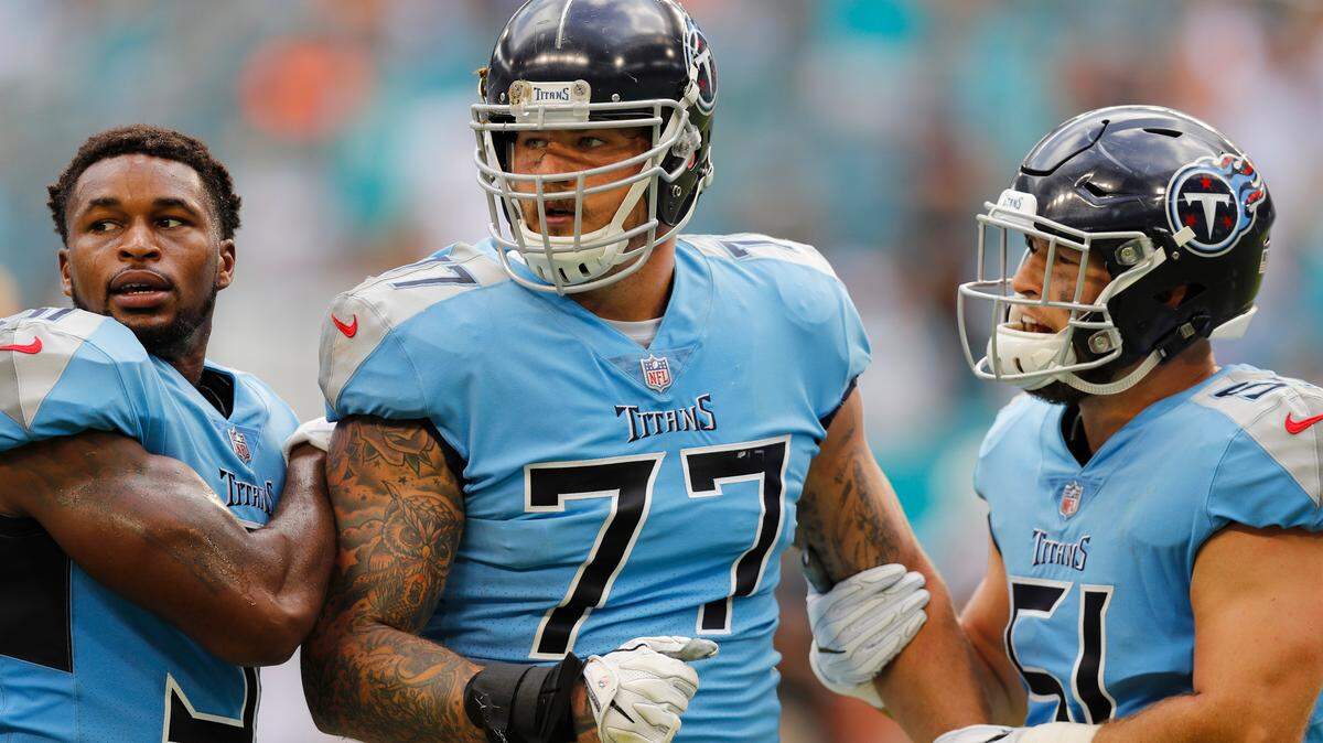 Tennessee Titans offensive tackle Taylor Lewan  is held back by defensive back Kevin Byard, No. 31, and linebacker Will Compton, No. 51, during a scuffle in the second half of Sunday’s game against the Dolphins.