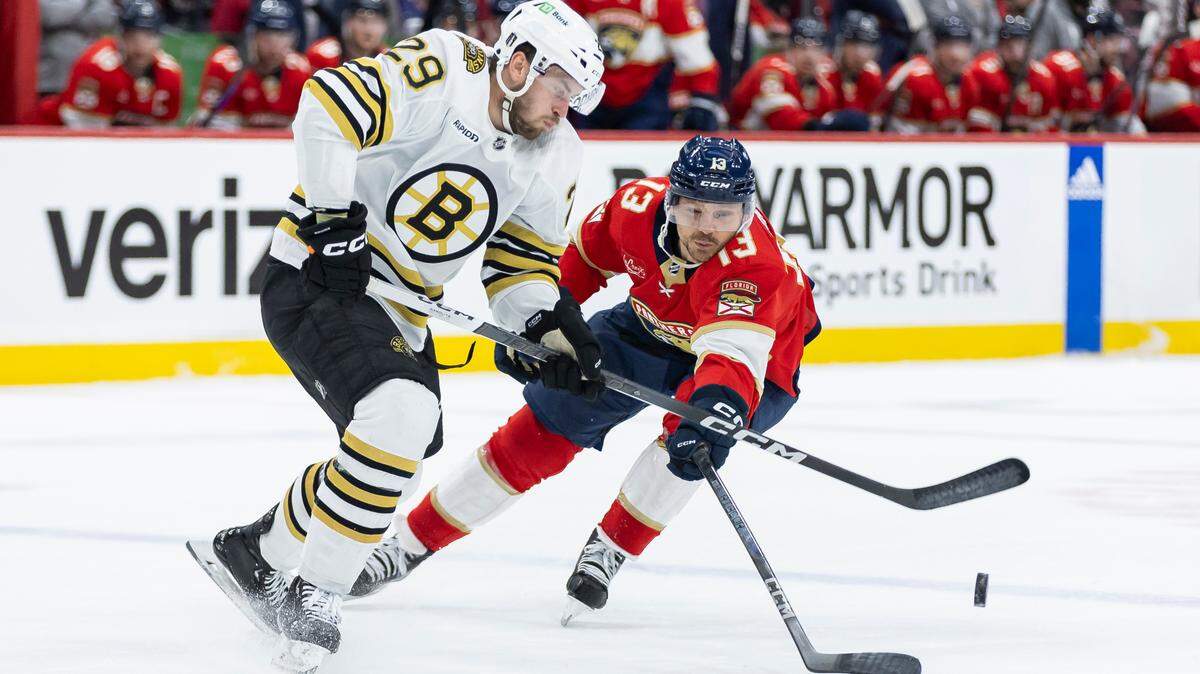 Florida Panthers center Sam Reinhart (13) and Boston Bruins defenseman Parker Wotherspoon (29) compete for the puck in the first period of Game 1 of the second-round series of the Stanley Cup Playoffs on Monday, May 6, 2024, in Sunrise, Fla.