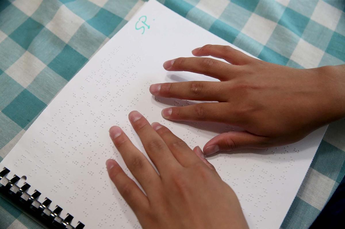 Silvio Plata 15, reads from a Braille book on June 12, 2019. The Miami high school sophomore will compete in the 2019 Braille Challenge National Finals in California.