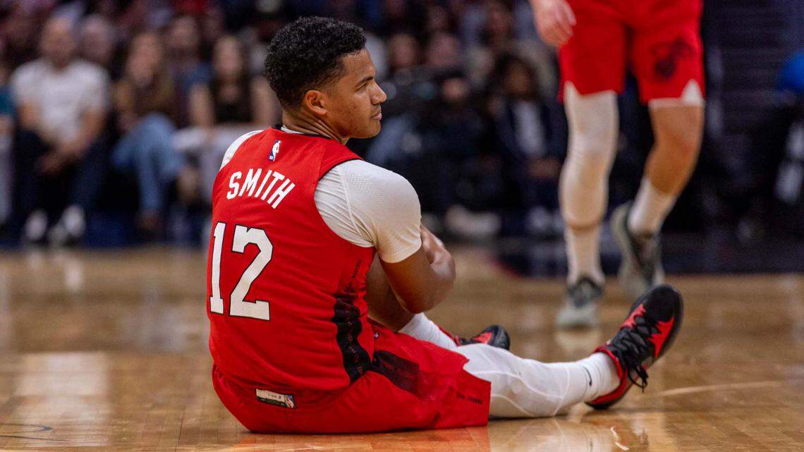 Miami Heat guard Dru Smith (12) grabs his leg after being injured on a play during the first half of an NBA game against the Brooklyn Nets at Kaseya Center on Dec. 23, 2024, in Miami.