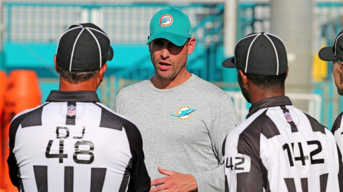 Miami Dolphins coach Adam Gase talks with referees during training camp at the Miami Dolphins training facility in Davie, Florida, August 3, 2018. 