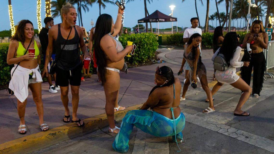 A group of tourists dance on Ocean Drive during spring break in Miami Beach on Monday, March 22, 2021.
