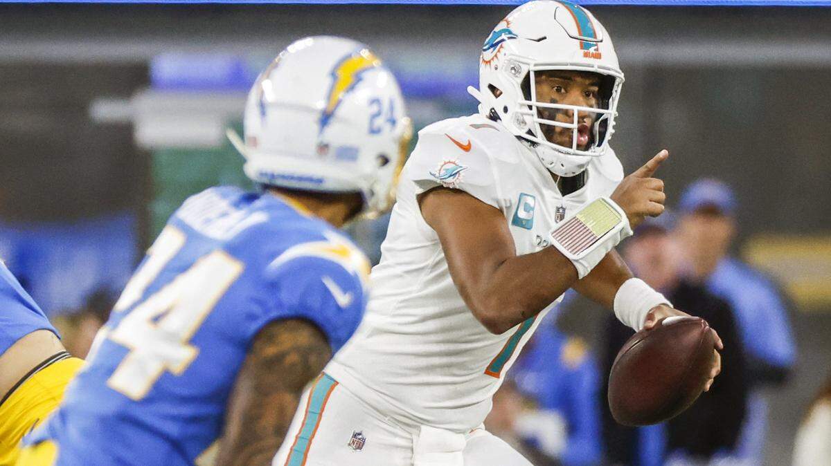 Miami Dolphins quarterback Tua Tagovailoa (1) scrambles as Los Angeles Chargers safety Nasir Adderley (24) gives chase in the fourth quarter at SoFi Stadium in Inglewood, California on Sunday, December 11, 2022.