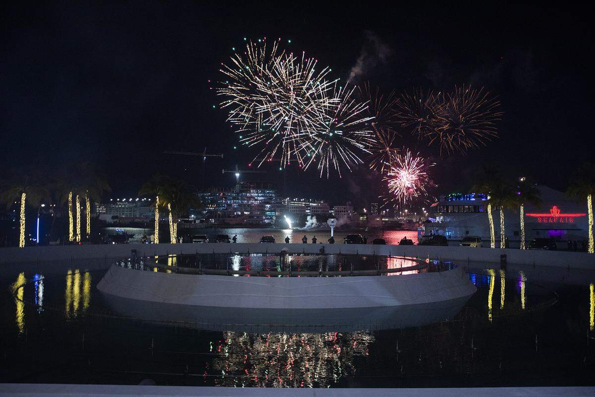 People watch a midnight fireworks display over Biscayne Bay to welcome 2026 at Bayfront Park.