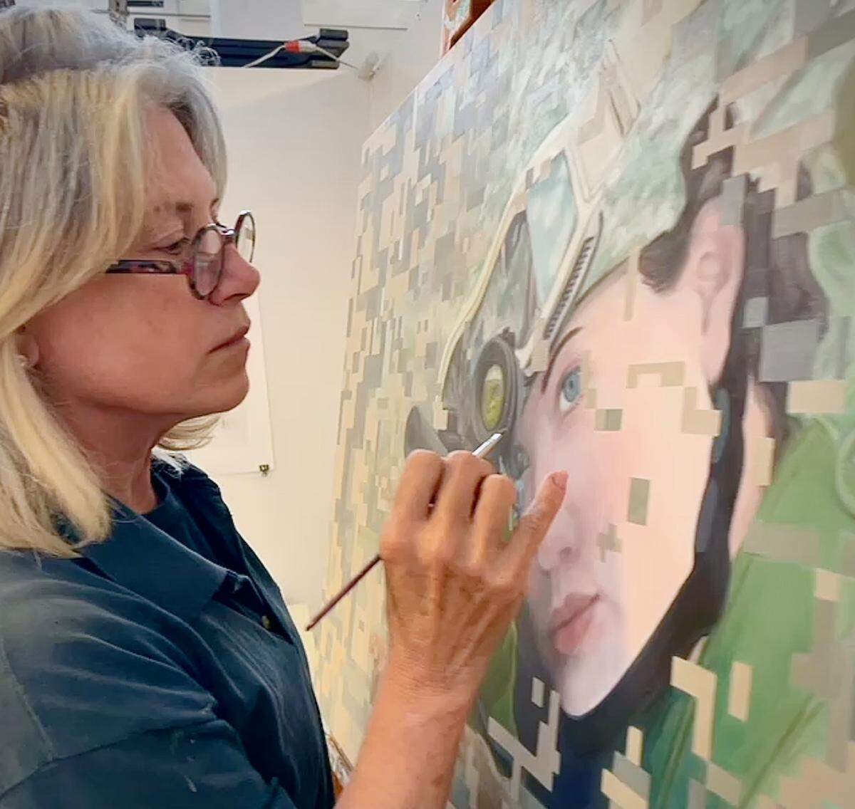 Mary Ellen Scherl works on one of the pieces from her multimedia project “Defending Democracy: Portraits of U.S. Military Women on Canvas and Film.” She’ll have a booth at the Coconut Grove Arts Festival.