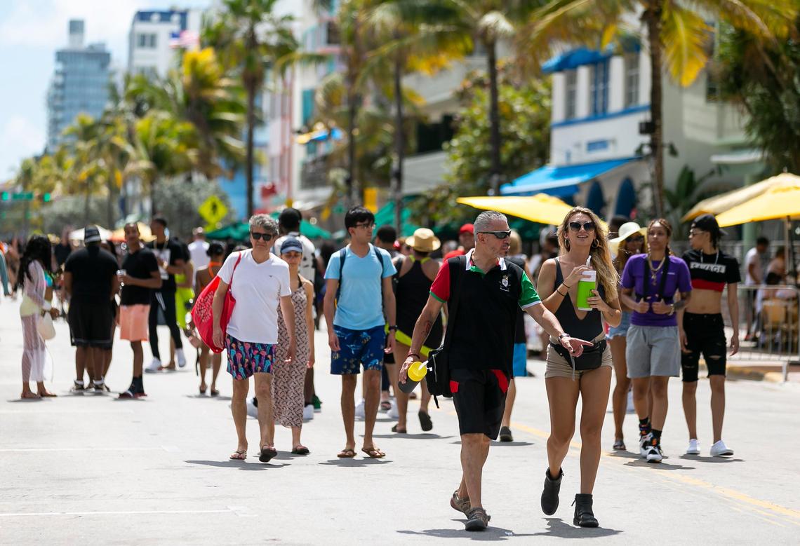 Beach goers walk down Ocean Drive in Miami Beach, Florida on Saturday, March 14, 2020. To limit large crowds and fight the spread of COVID-19, Miami Beach officials are closing three blocks of the public beach on South Beach beginning Saturday and lasting indefinitely.